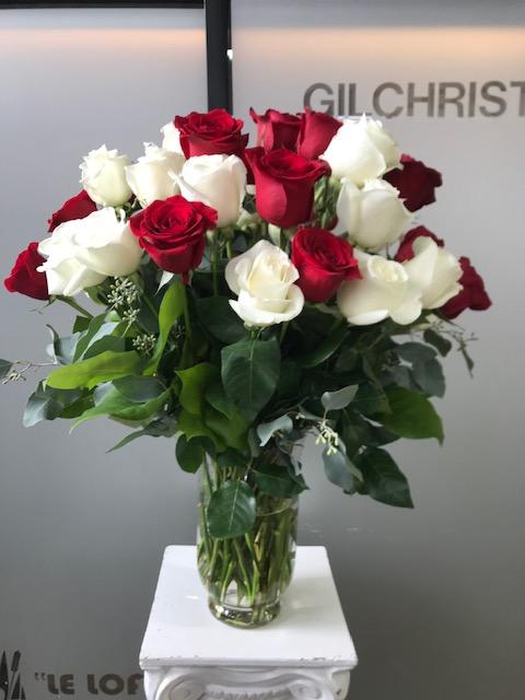 24 red and white roses in a vase arrangement